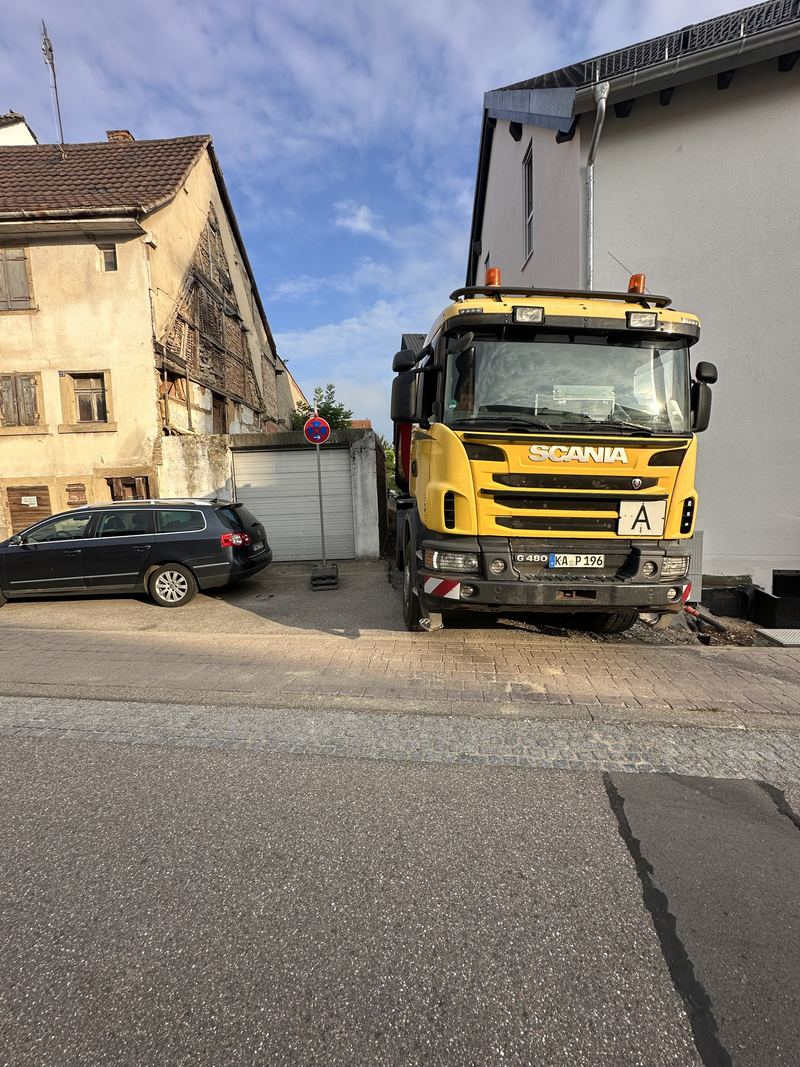 Scania-Zugmaschine von Godec steht in einer schmalen Lücke zwischen zwei Häusern